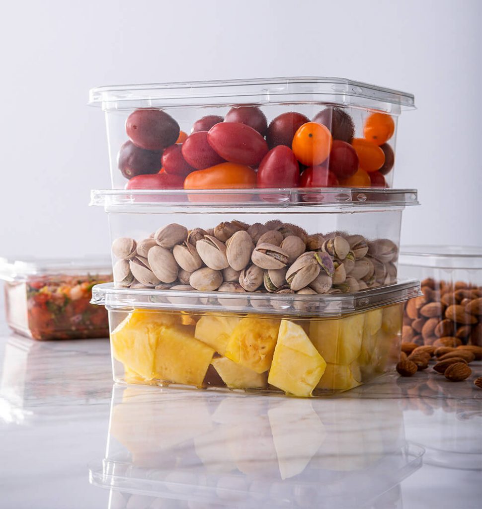 Stacked packaging containers with tomatoes, nuts and pineapples