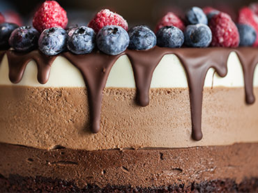 cake with melted chocolate and fruit on top