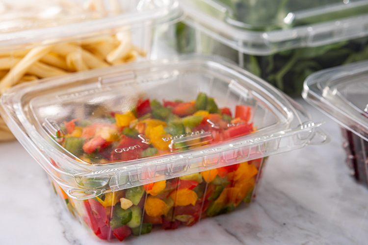 clamshell container holding a variety of red, yellow and green cut peppers